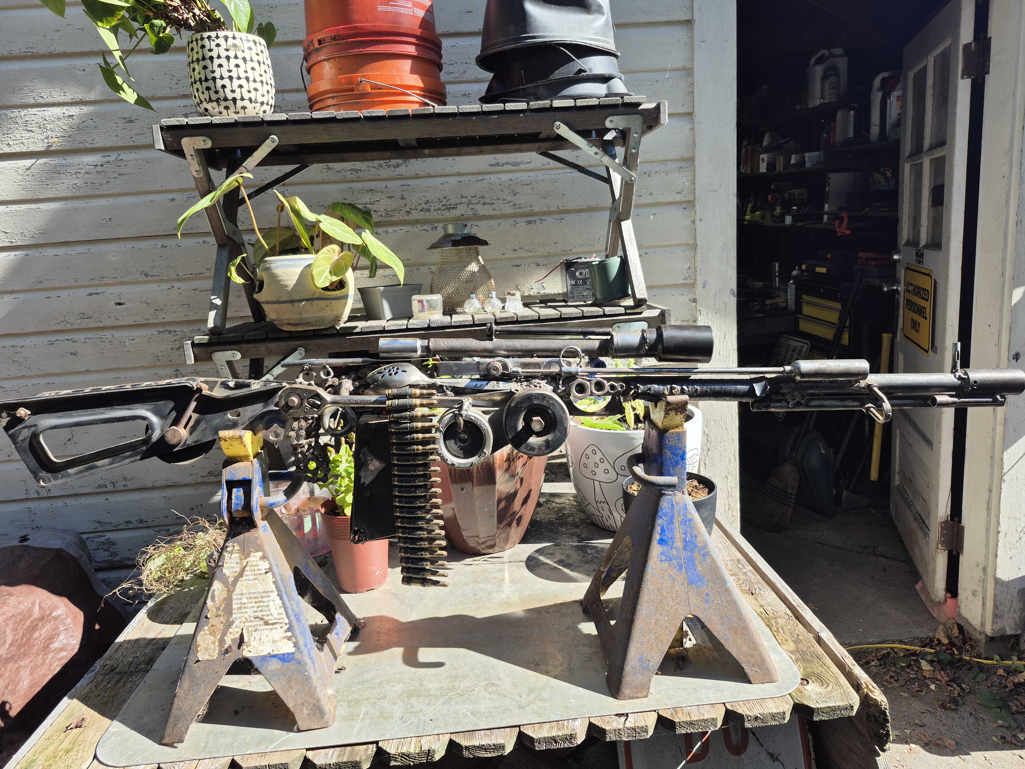 Steampunk scrap-metal rifle sculpture on jack stands